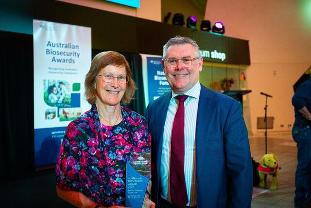 Eileen Scott and Minister Murray Watt infront of a post of Australian Biosecurity Awards.