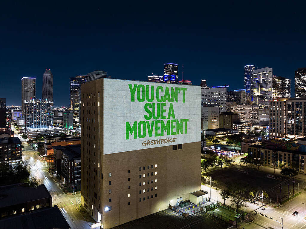 Wide angle aerial image showing a huge projection on a building in downtown Houston, reading