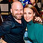 a couple poses together at a table at a fancy dinner