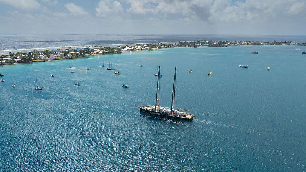 Rainbow Warrior ship entering port in Majuro, while being accompanied by three traditional Marshallese canoes. © Bianca Vitale / Greenpeace