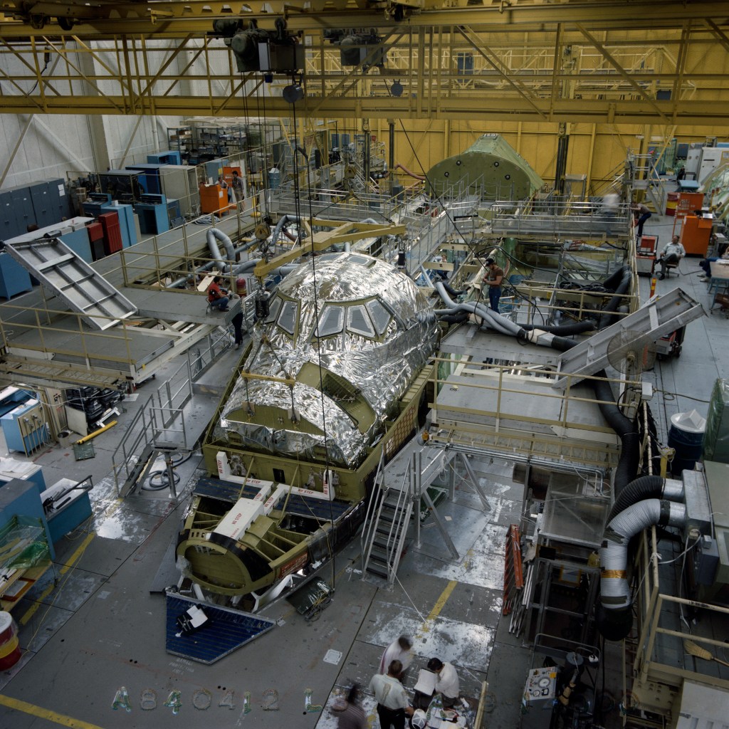 View inside an assembly hangar of a partially built space shuttle orbiter.