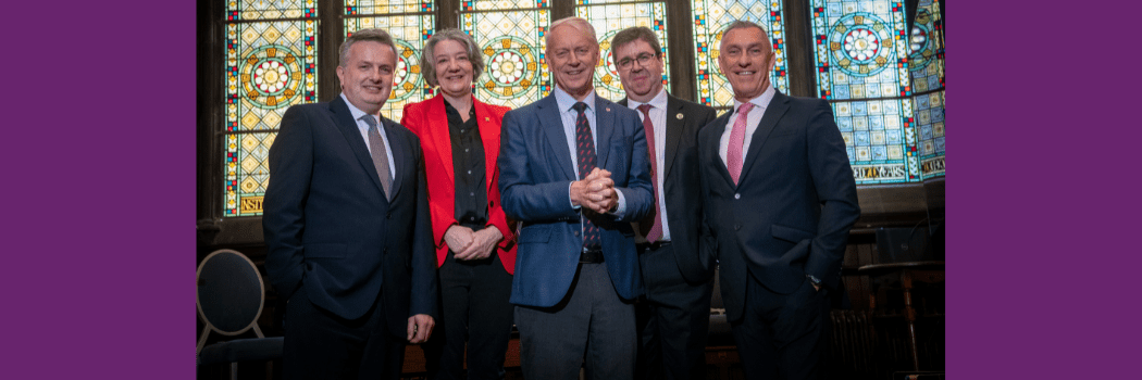 Representatives of the five North East universities stood in front of a stained glass wiindow