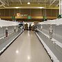 A supermarket aisle with empty shelves on both sides