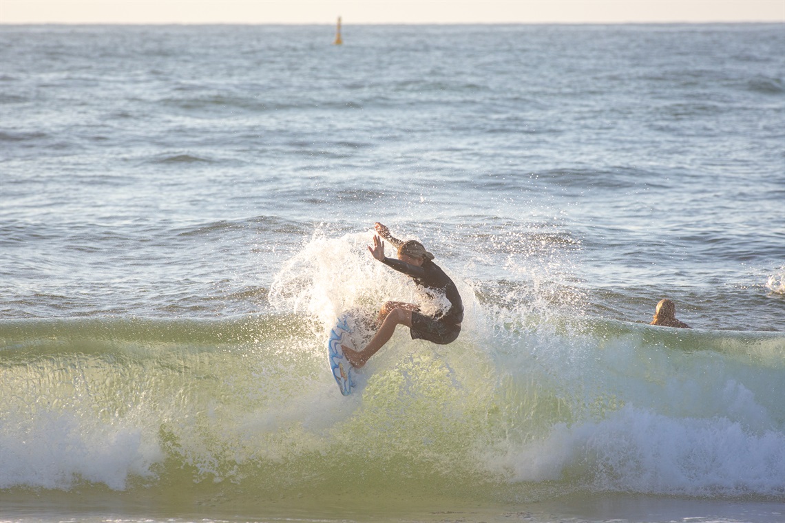 A surfer rides a wave at redhead beach