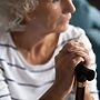 An older woman holding a stick
