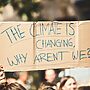 A person holds a sign that reads