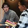 A student listens intently while another person speaks at an eviction court hearing.