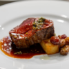 Slice of steak, garnished and served with potatoes