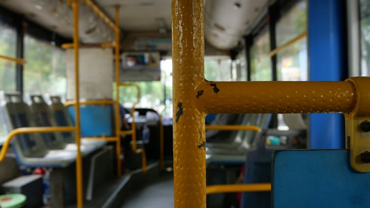 A yellow bar in front of a bus interior